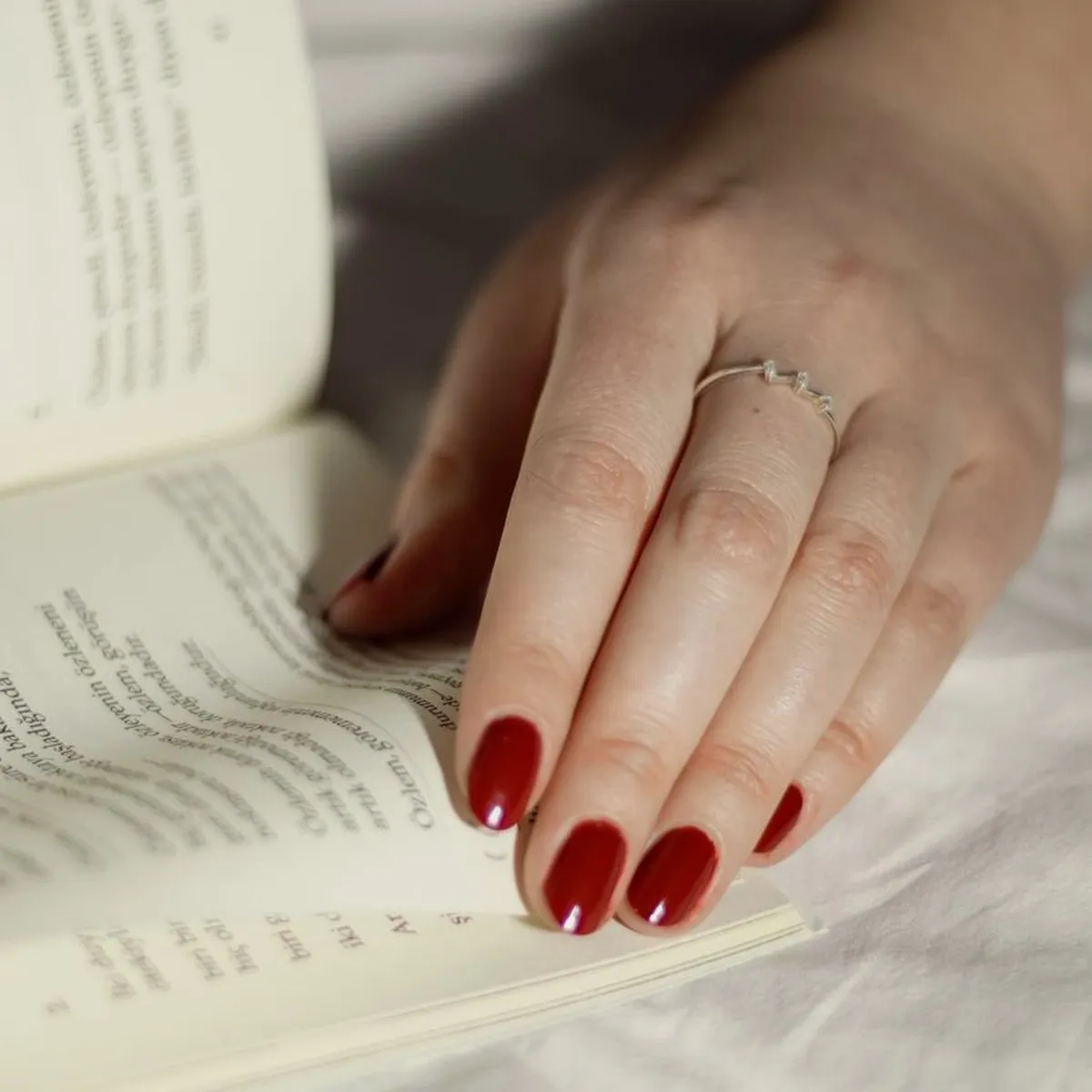 Mão com manicura sobre um livro